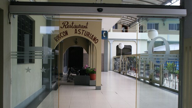 A restaurant entrance with a sign reading "Restaurant Rincón Asturiano" and a glass door. - Hotel Olimpico Quevedo (Quevedo)