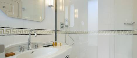 A modern bathroom with a large sink, mirror, and shower.