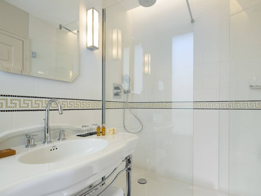 A modern bathroom with a large sink, mirror, and shower.