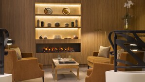 Una sala moderna con chimenea, sofás y estanterías con adornos.