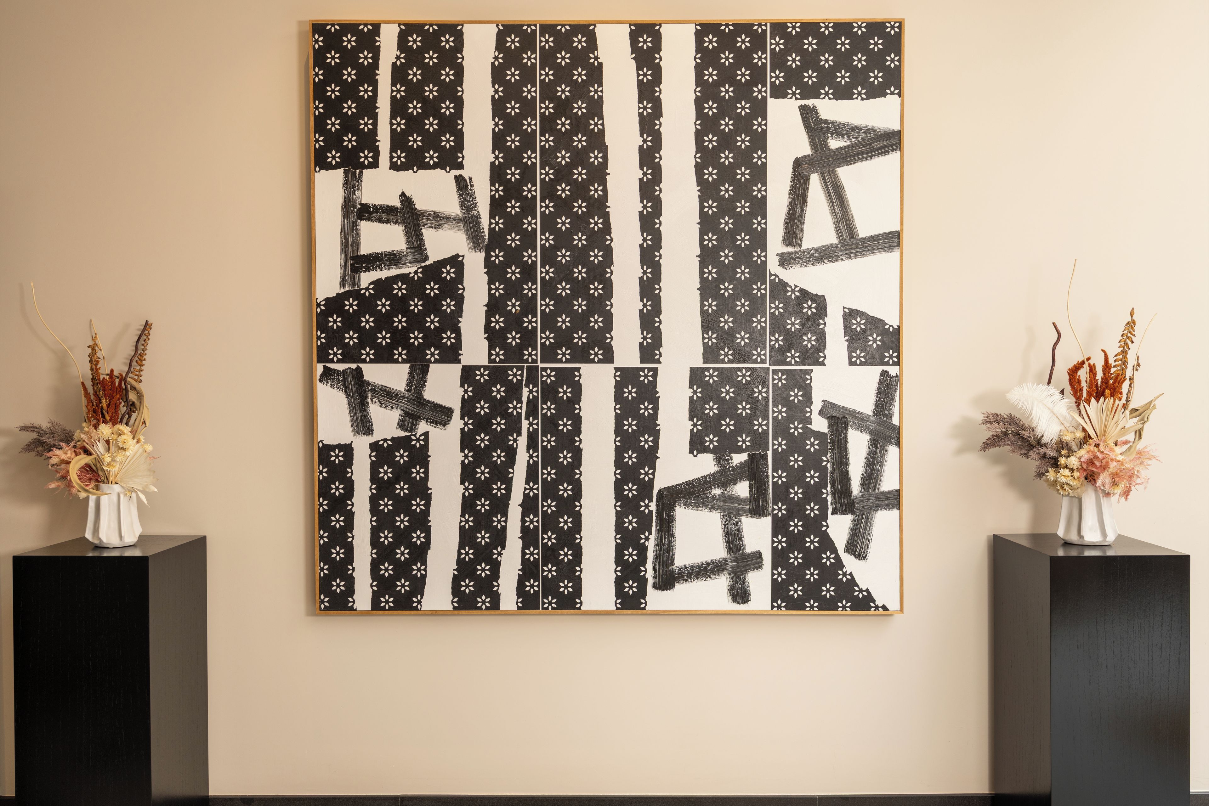 Una gran obra de arte abstracta con patrones blanco y negro en una pared.