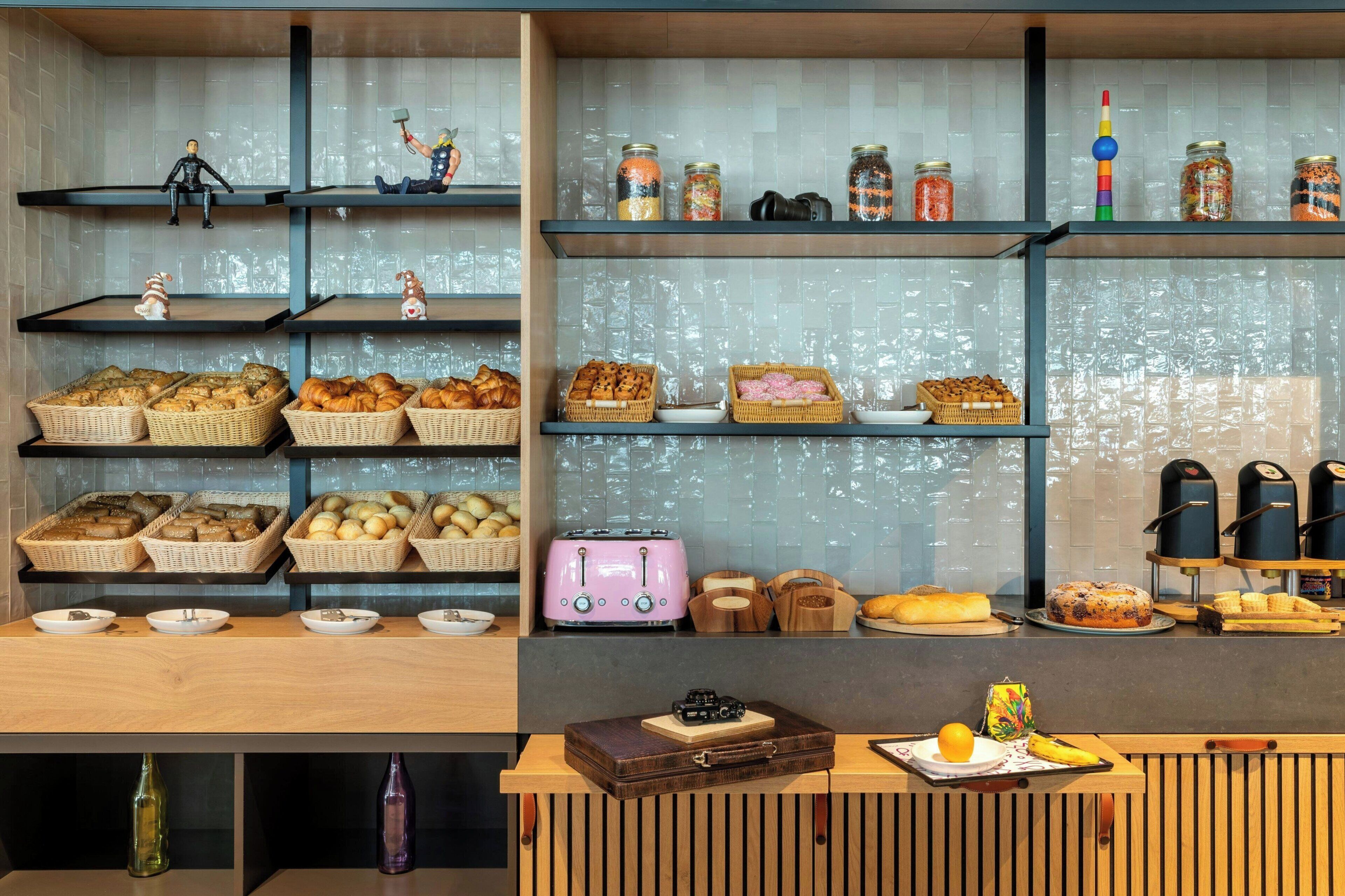 A bakery display with various baked goods and jars of preserves.