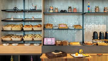 A bakery display with various baked goods and jars of preserves.