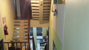 A staircase leading to a landing with a view of a kitchen area.