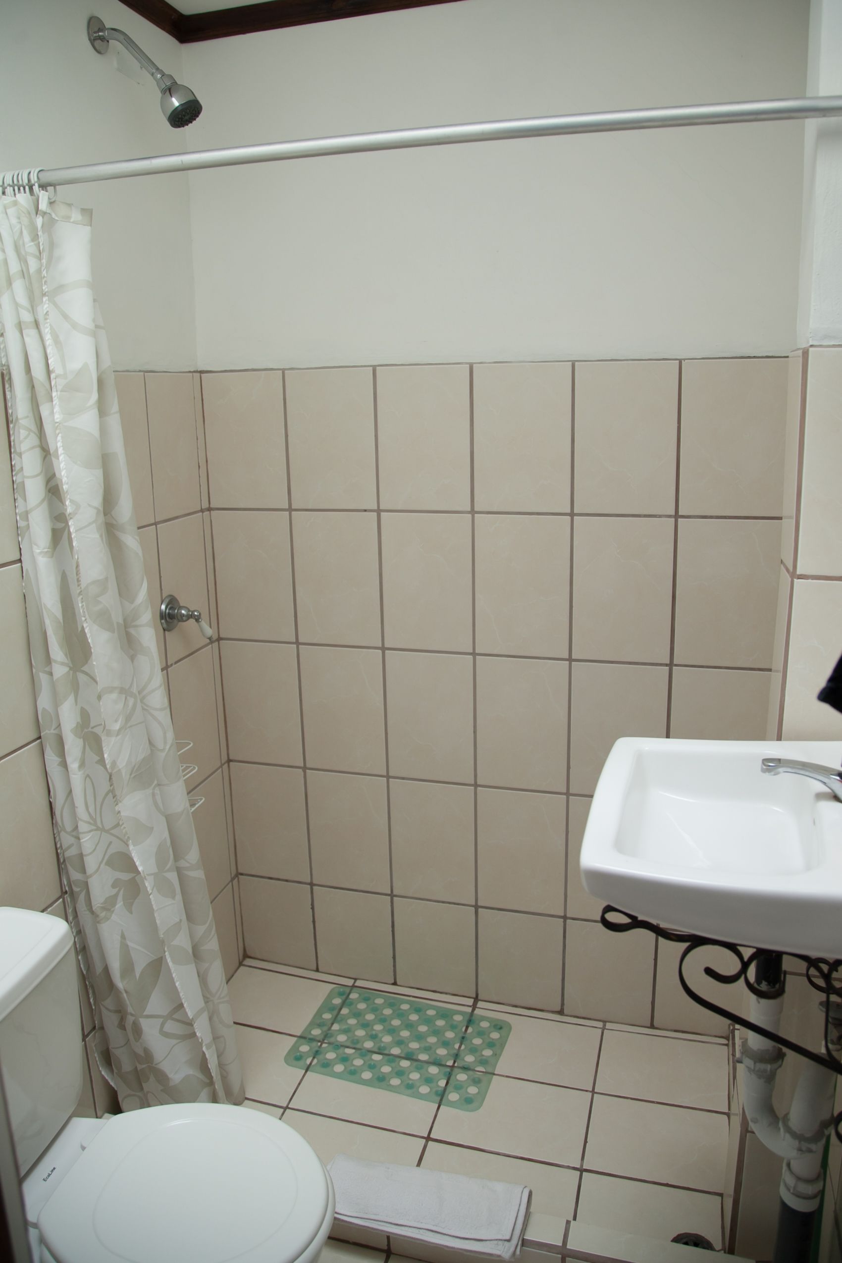 A bathroom with a shower, toilet, and sink.