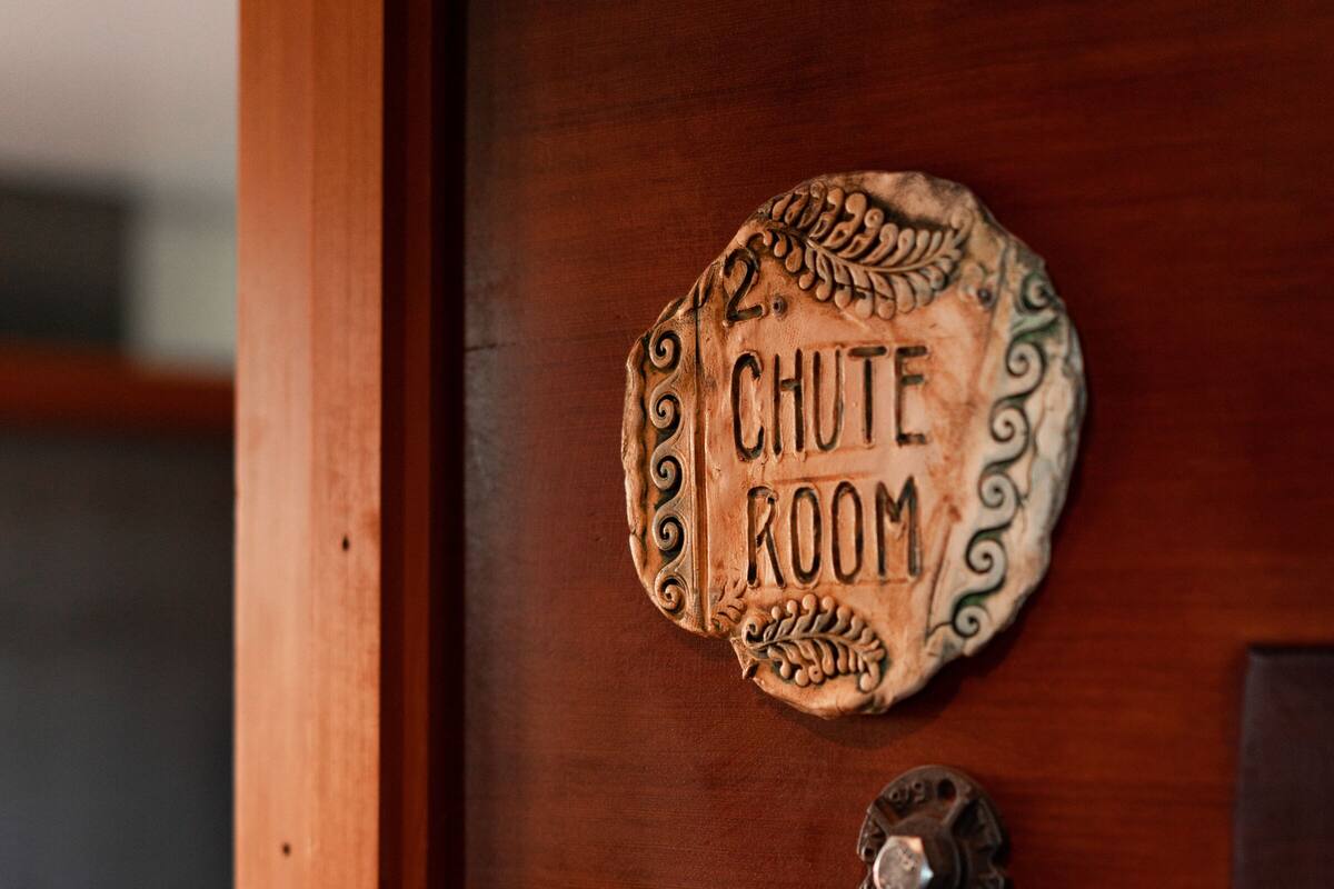 Una puerta de madera con un letrero que dice "CHUTE ROOM" y dos manijas de metal.