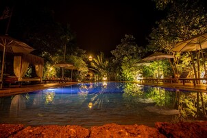 Una piscina al aire libre, sombrillas, sillones reclinables de piscina