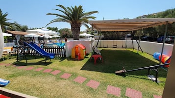 Enjoy a fun-filled family vacation with a play area featuring a slide, playhouse, and swing set.