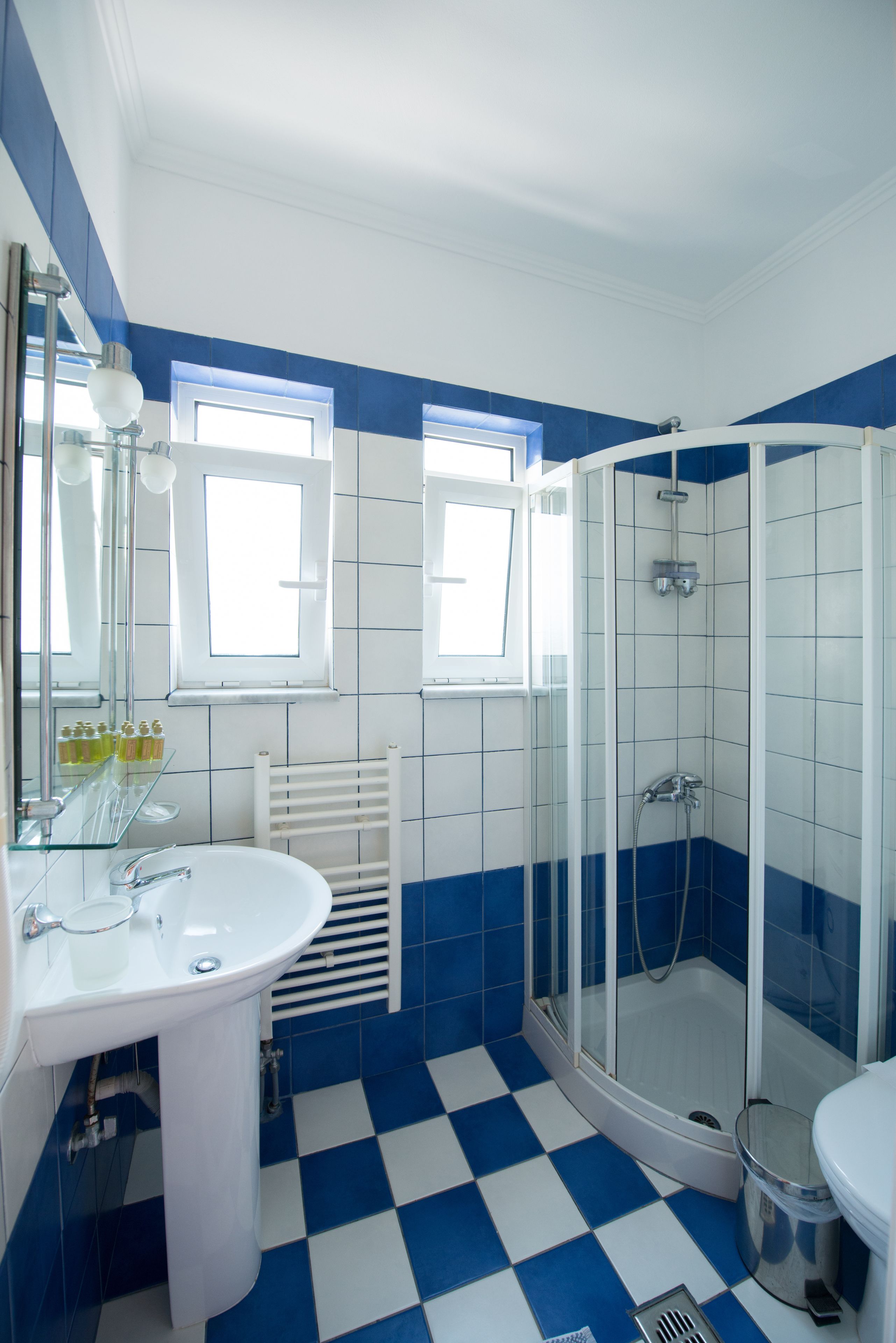 A bathroom with a white sink, a glass shower enclosure, and a white toilet.