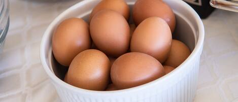 A white ceramic bowl containing several brown eggs.