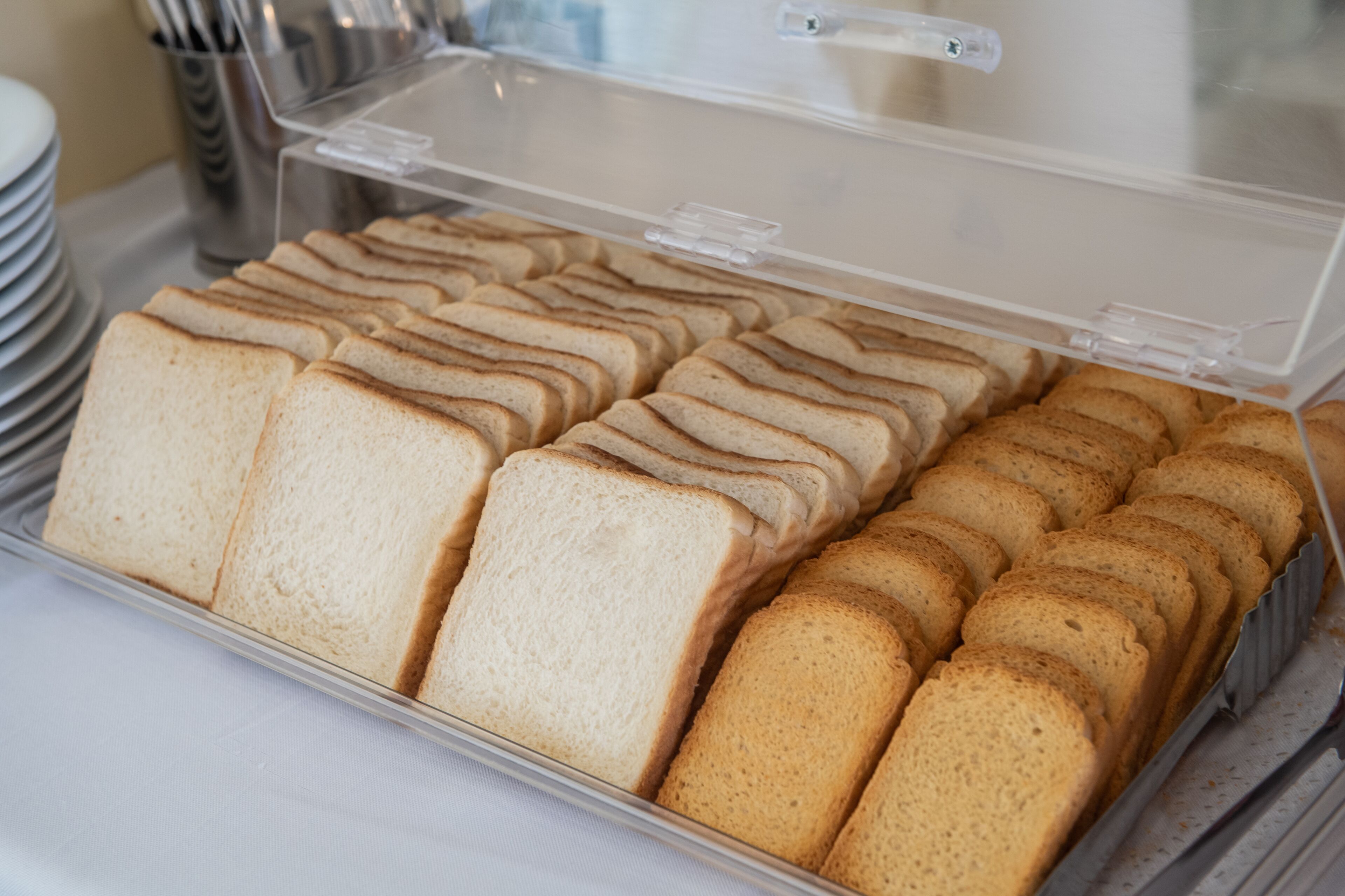 A tray of sliced bread in a clear plastic container.