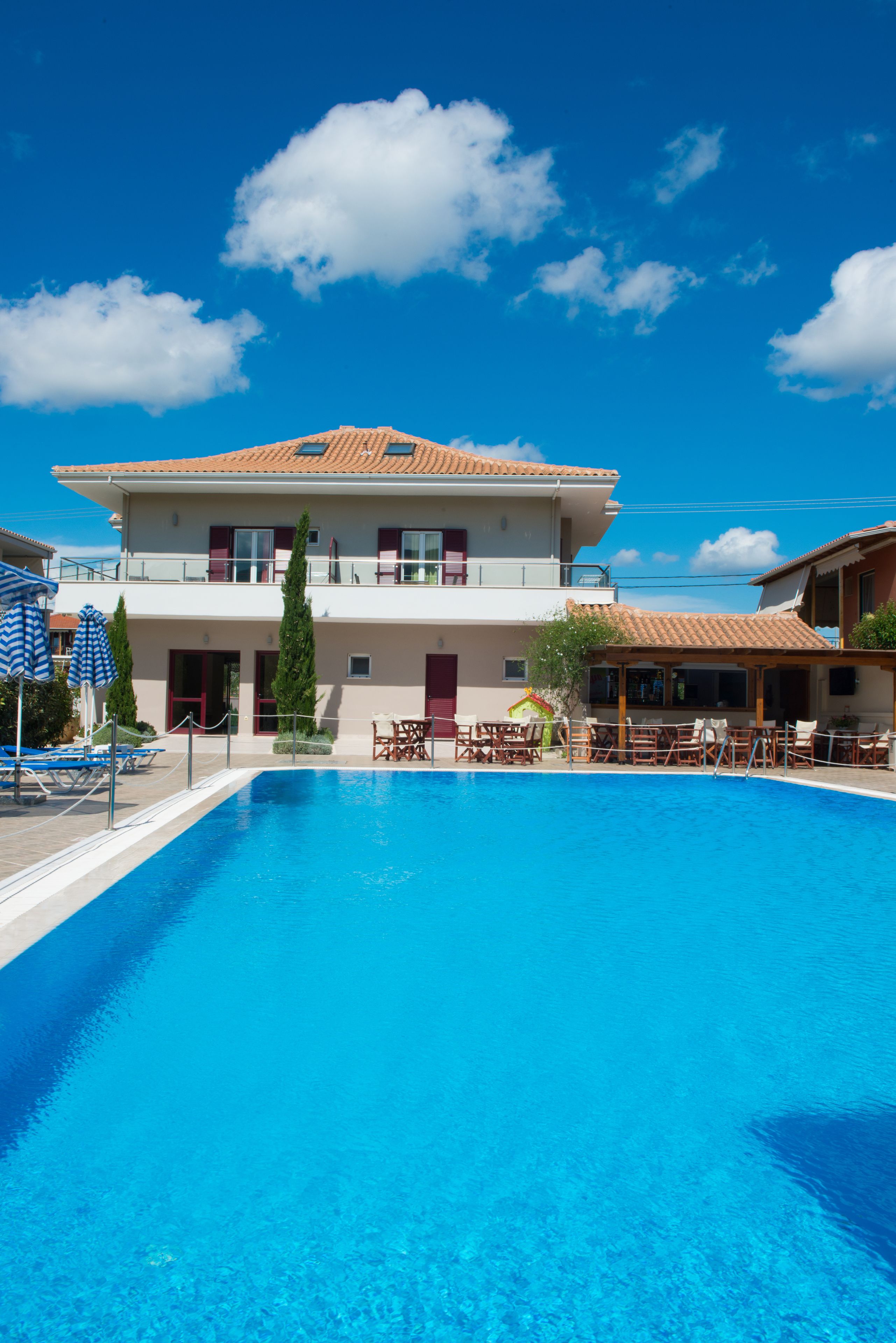 Un edificio di due piani con una piscina di fronte.