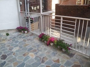 Enjoy the serene views from this balcony with potted plants and a door leading to a space.