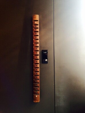 A wooden flute placed on a dark surface next to a black object. - Nook Seoul (Seoul)