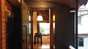 A wooden interior hallway with a bench and a table, leading to a room with a view. - Nook Seoul (Seoul)