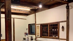 A kitchen with wooden cabinets, a white countertop, and a built-in dishwasher. - Nook Seoul (Seoul)