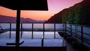 A balcony with a view of the sea and mountains during sunset. - Hotel Park (Gifu)