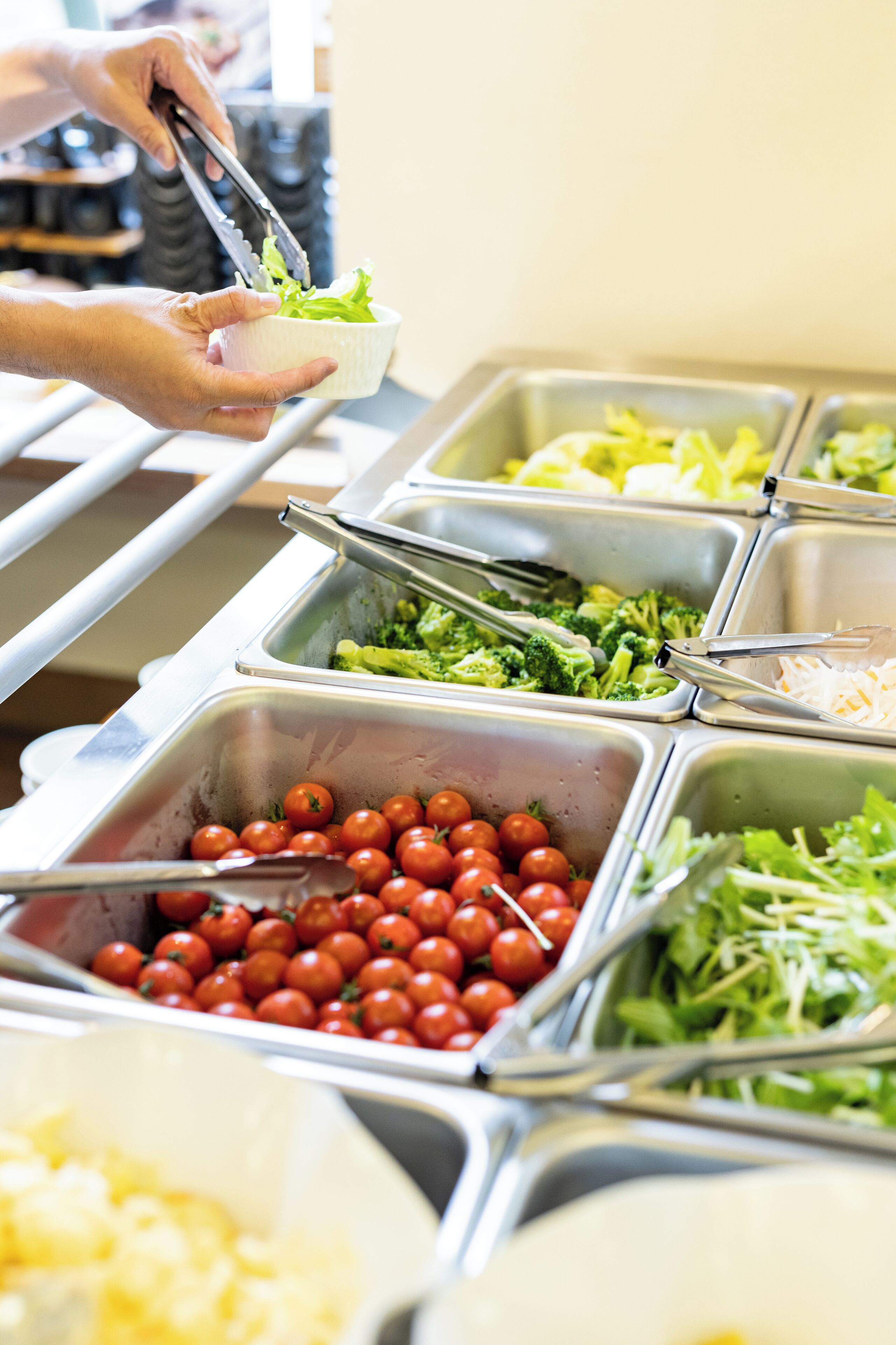 Un buffet proposant une variété de plats, notamment des tomates, des brocolis et des légumes verts.