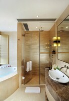 A modern bathroom with a glass-enclosed shower, a bathtub, and a vanity with a sink.