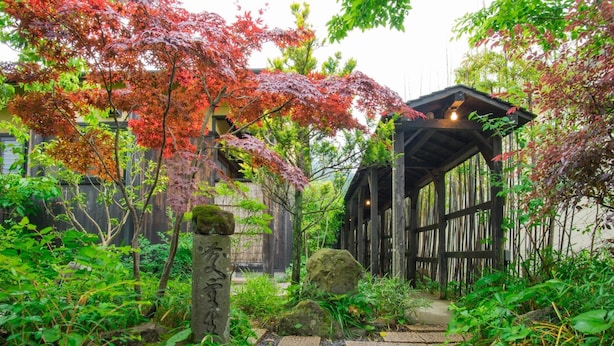 A wooden pathway leading to a traditional Japanese-style building with a thatched roof. - Yurari Rokumyo (Yufu)
