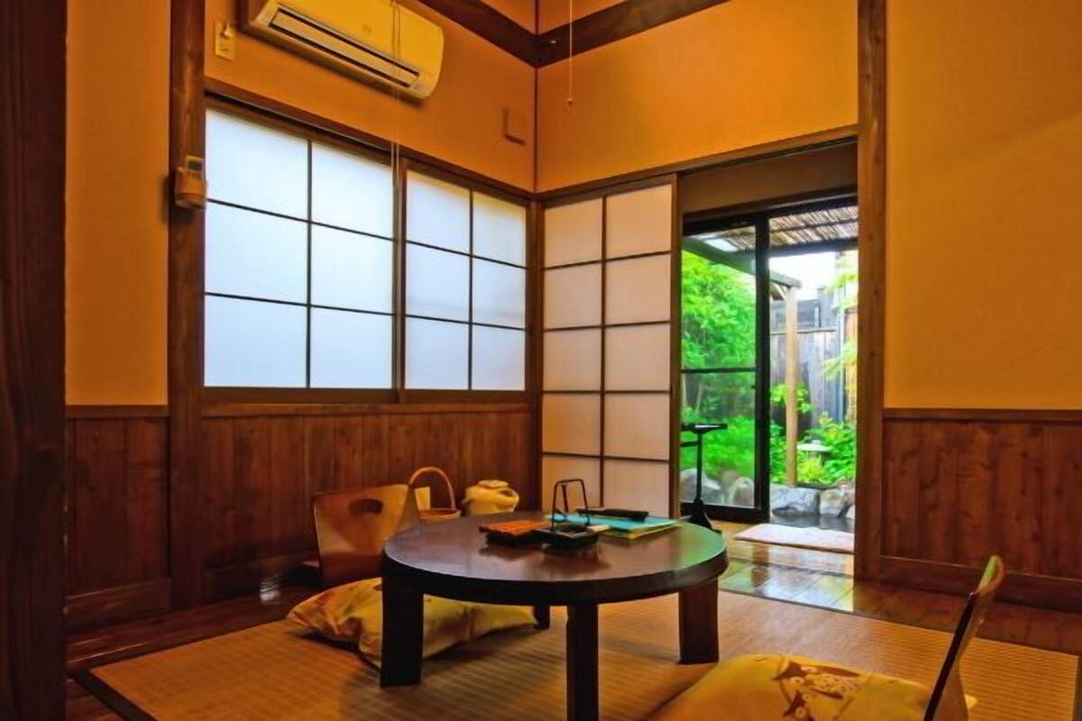 A traditional Japanese-style room with tatami flooring, a low table, and sliding doors.