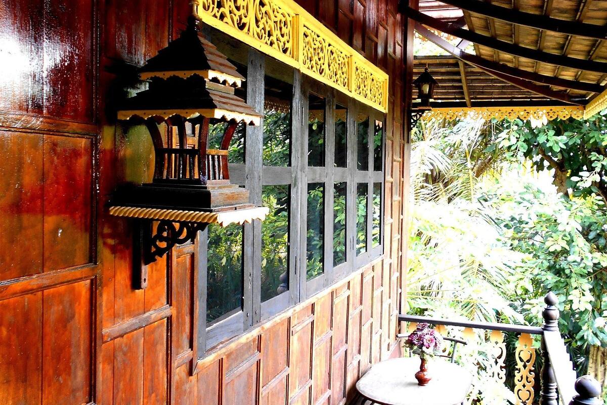 Ein Holzhaus mit Balkon, Tisch und Stühlen.