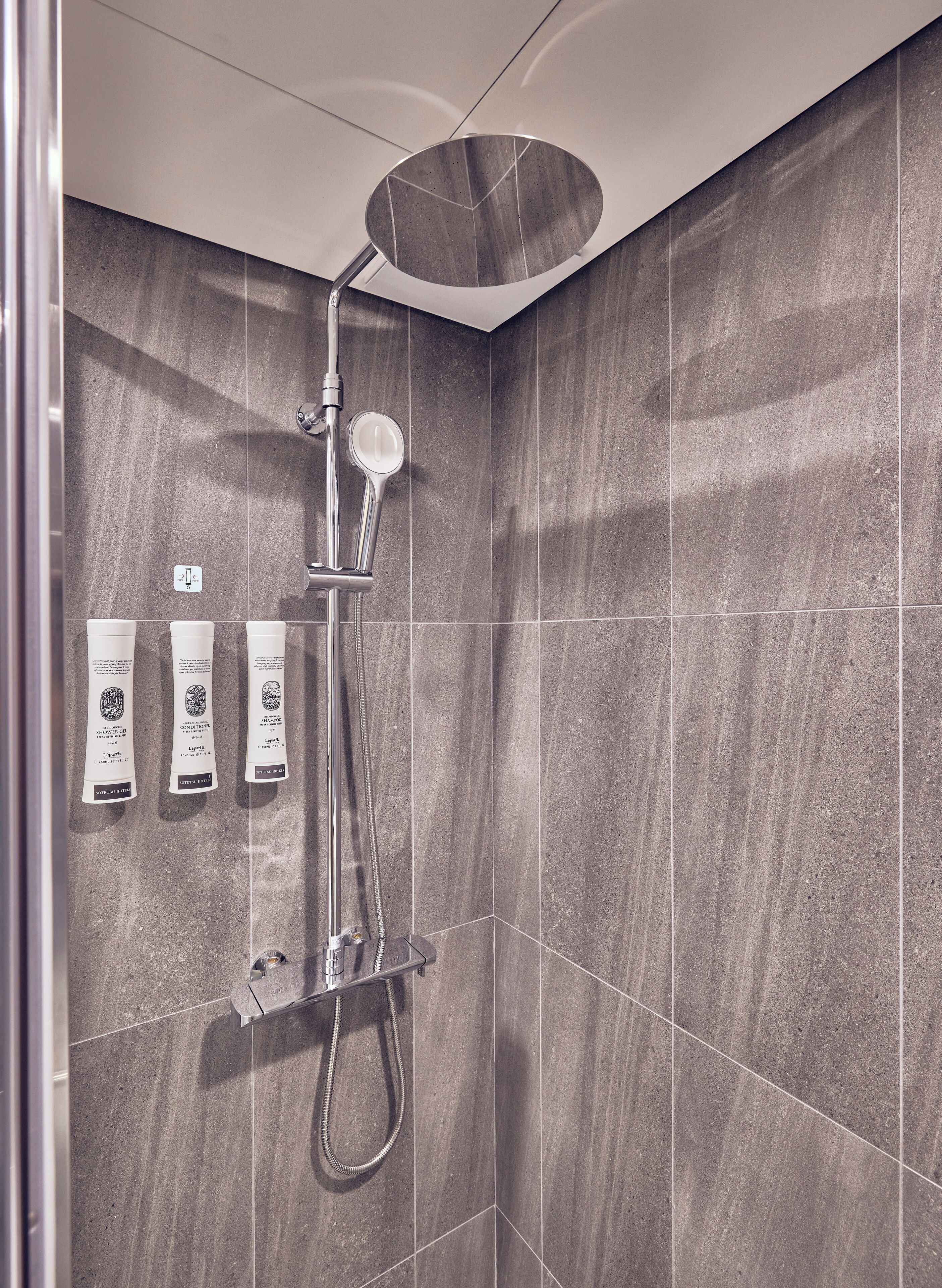 A modern shower with a handheld showerhead and a rain shower attachment.