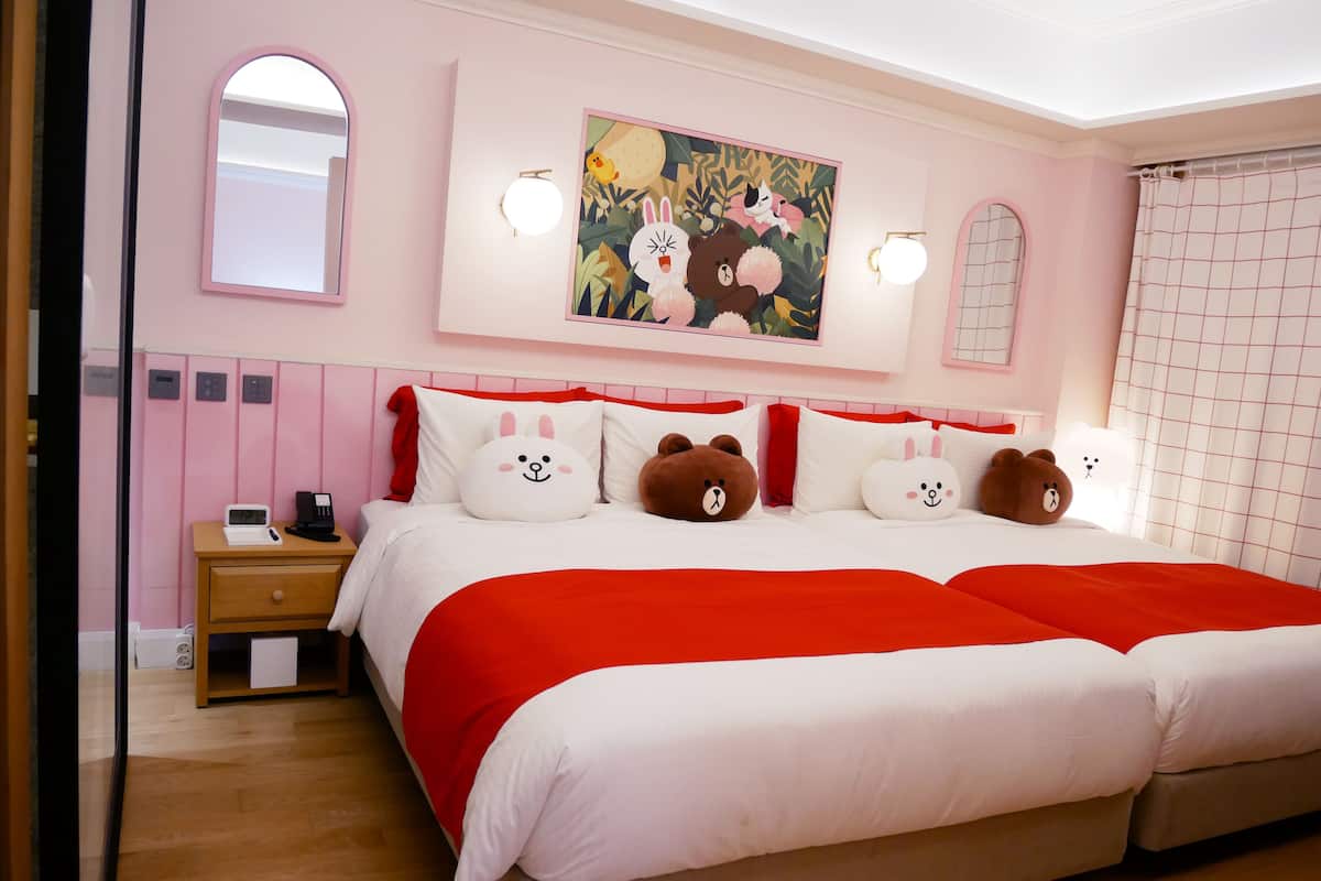 Ein Schlafzimmer mit einem großen Bett, einem Nachttisch, einem Spiegel und einem an der Wand hängenden Gemälde.