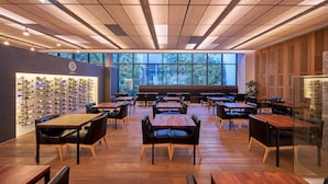 A restaurant with wooden tables and chairs, a wine wall, and large windows. - Sotetsu Hotels The Splaisir Seoul Myeongdong (Seoul)