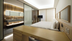 A modern hotel room with a skylight, a large bed, a wooden desk, a bathroom with a vanity, and a flat-screen TV. - Sotetsu Hotels The Splaisir Seoul Myeongdong (Seoul)