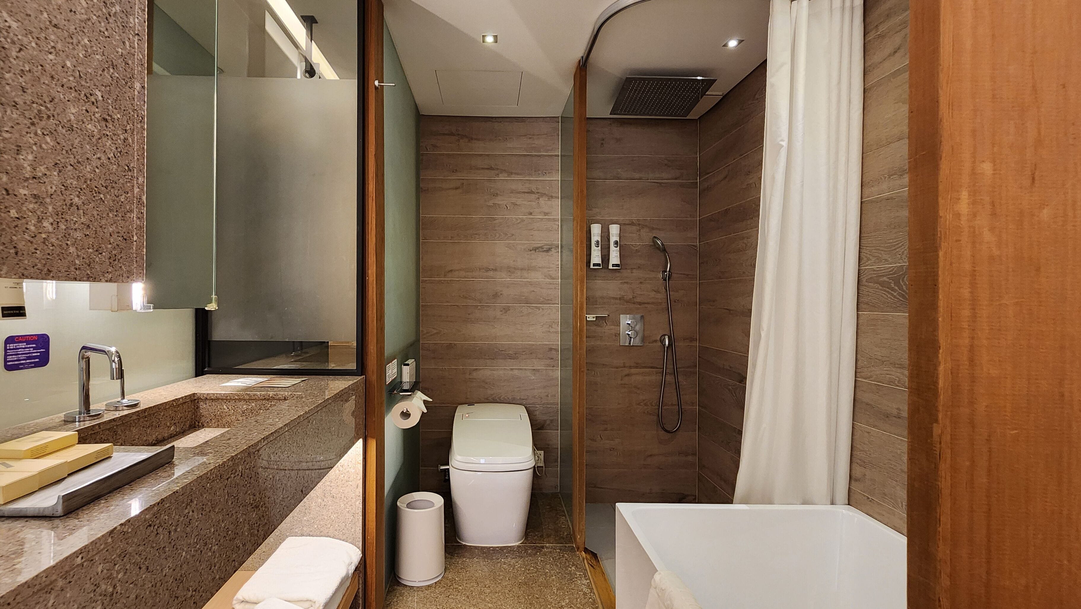 A modern bathroom with a shower, toilet, and sink.