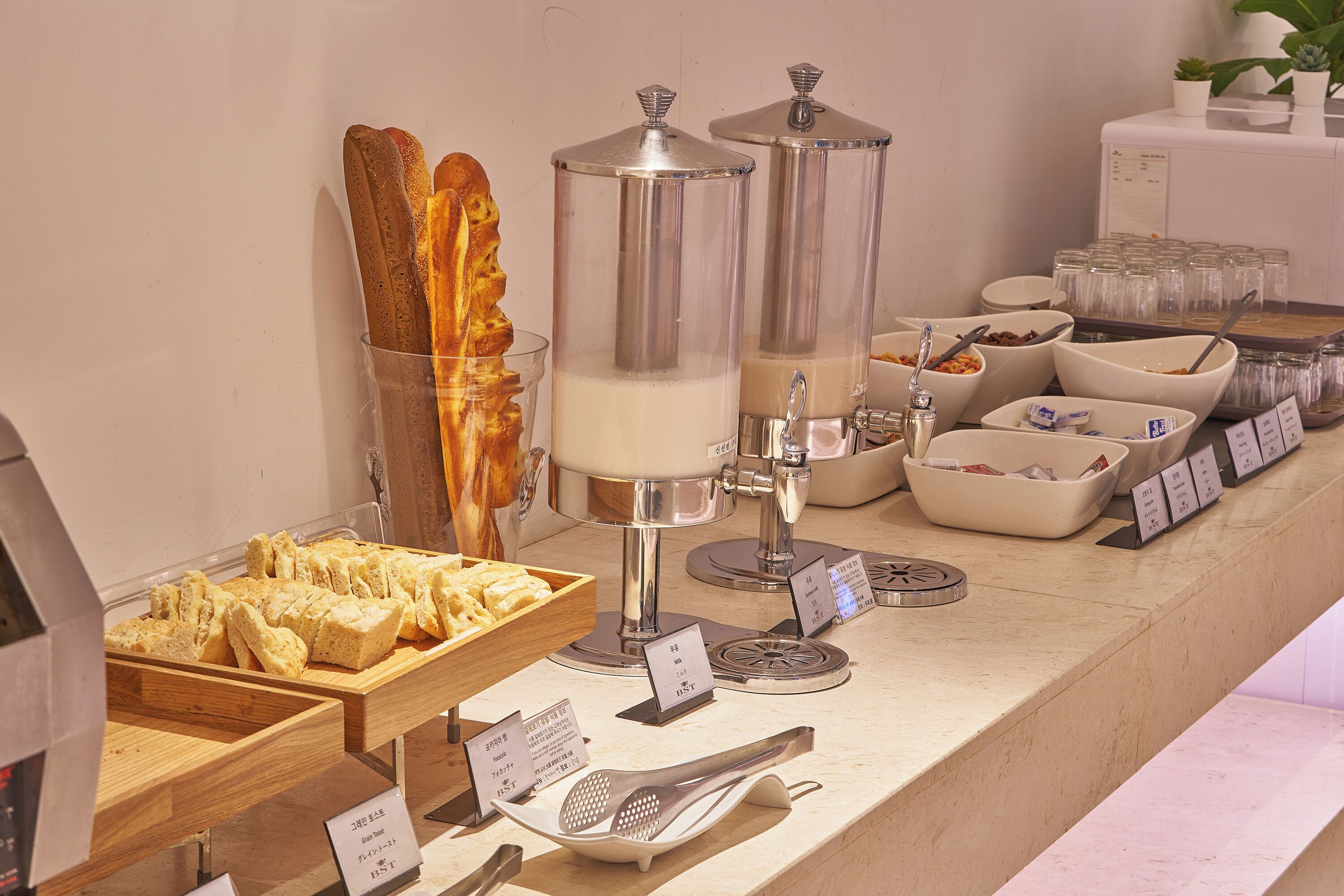 Un'area buffet con diversi cibi, tra cui pane, latte e condimenti.