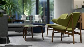 A modern living room with a sofa, a green armchair, a small table, and a coffee table.