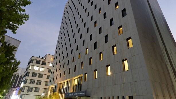 A modern high-rise building with a grid of windows, a ground-level entrance, and a well-lit street. - Sotetsu Hotels The Splaisir Seoul Myeongdong (Seoul)