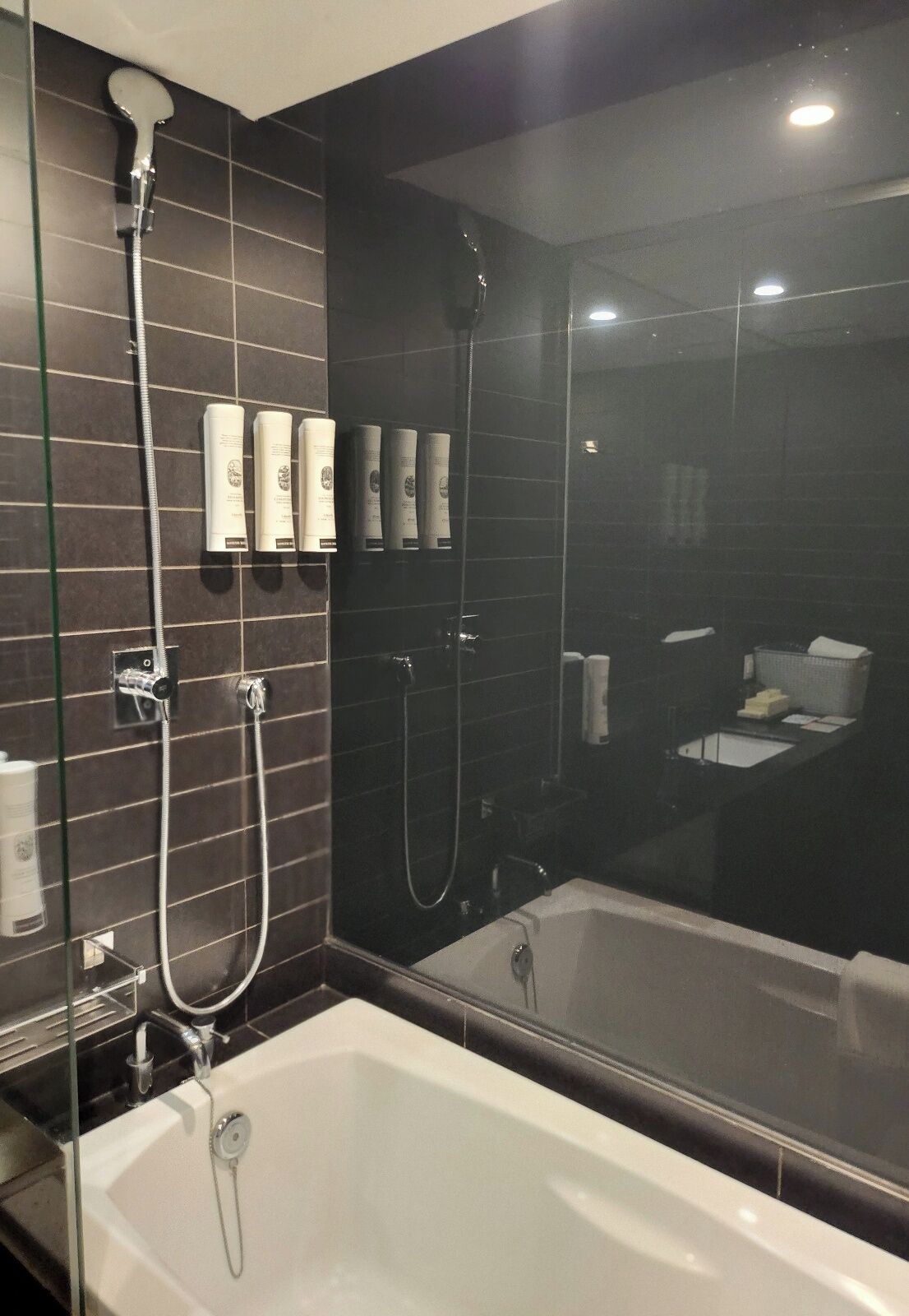 A modern bathroom with a large bathtub, a glass-enclosed shower area, and a mirror reflecting the space.