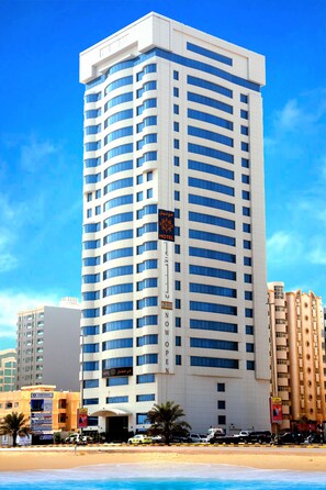 A tall hotel with a modern design, featuring a prominent entrance and multiple floors. - V Hotel Fujairah (Al-Fujairah)