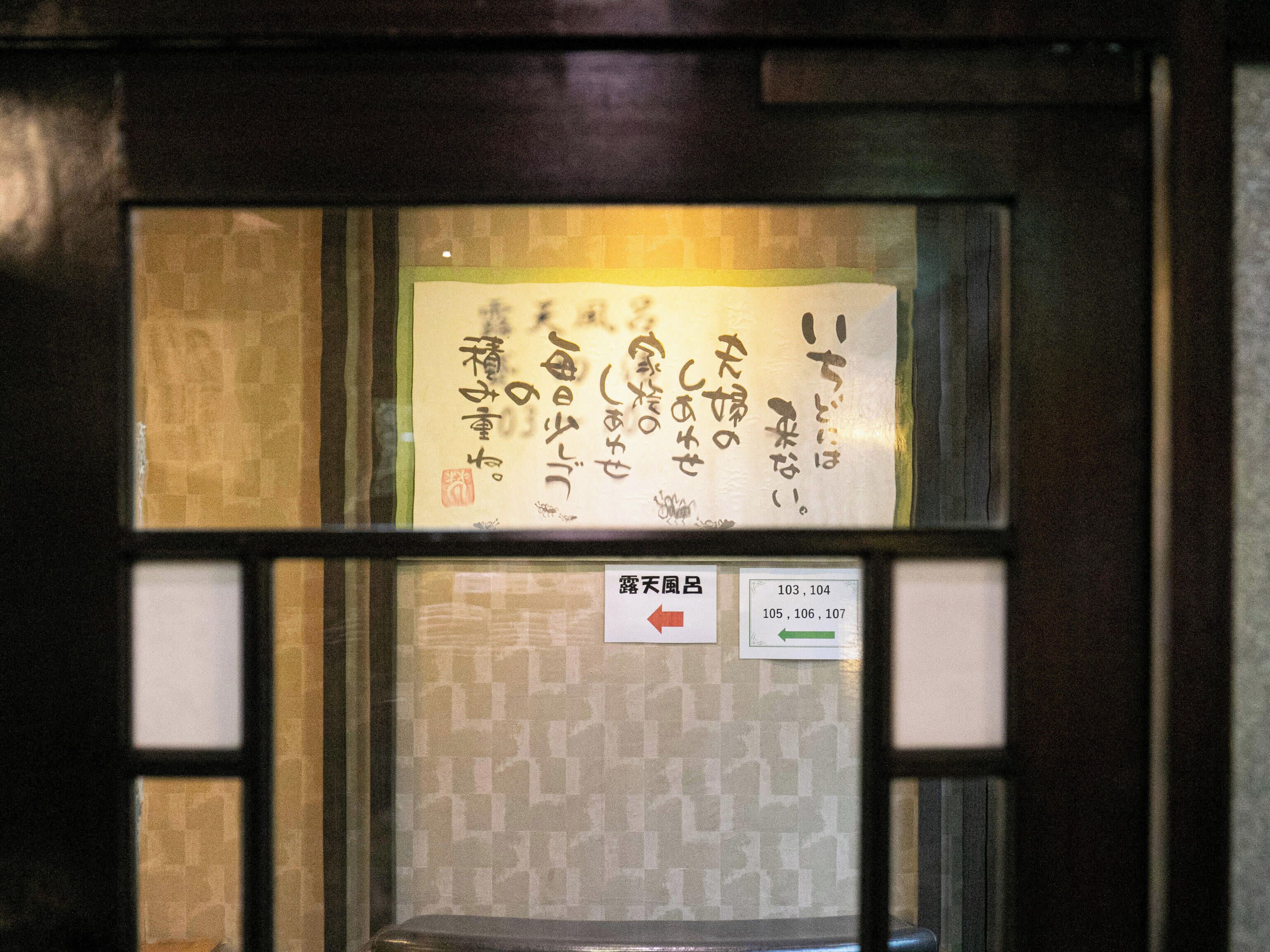 A room with a window displaying a sign with Japanese characters and directional arrows.