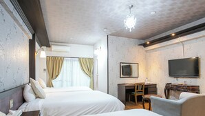 Habitación de hotel con dos camas, un escritorio, una silla, un televisor y un candelabro.