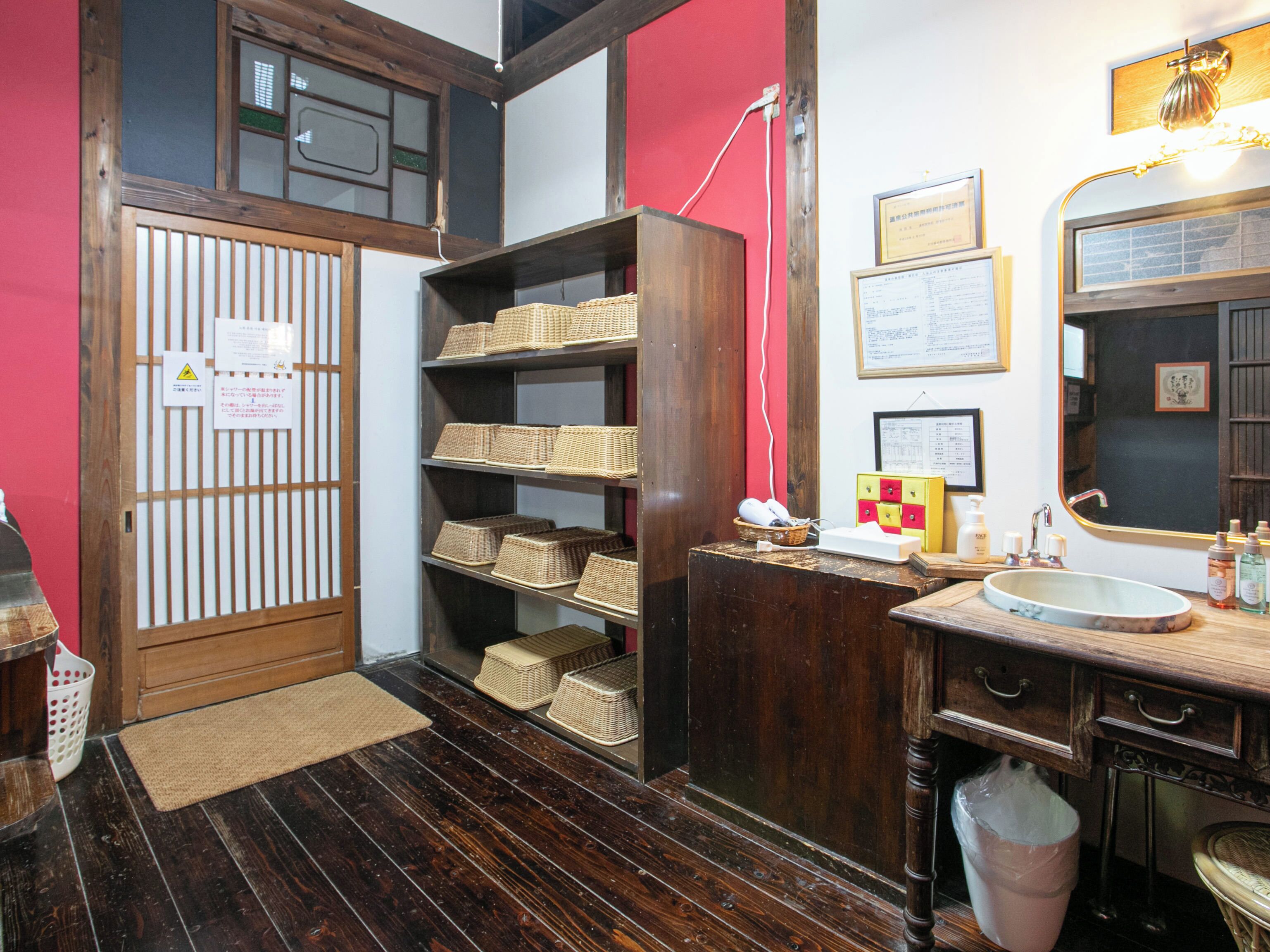 Un baño de estilo japonés tradicional con estantes de madera, un lavabo y un espejo.
