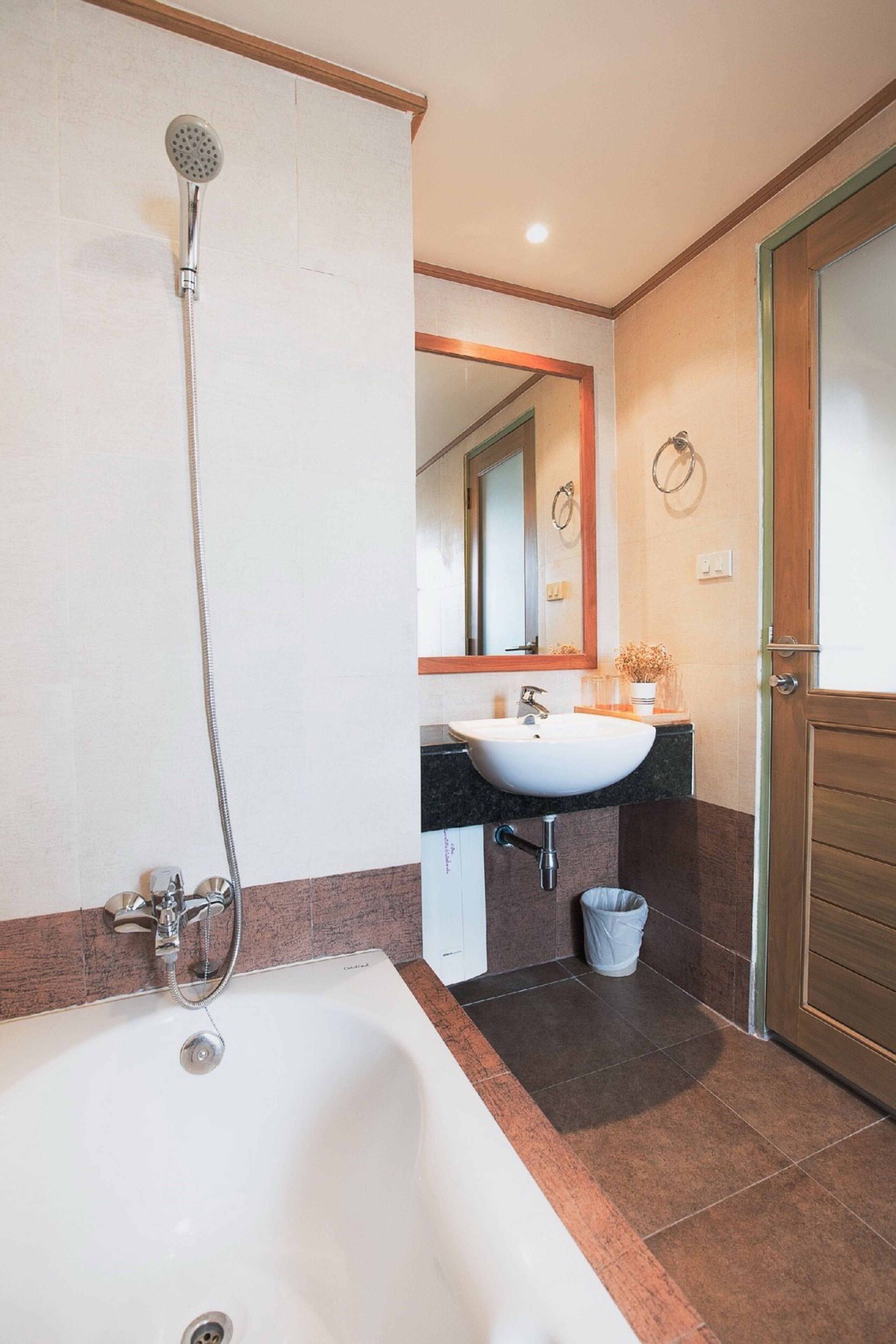 Une salle de bain équipée d’une baignoire, d’un lavabo, d’une douche et d’un miroir.