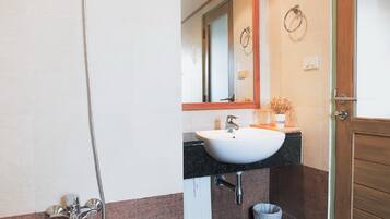 Une salle de bain équipée d’une baignoire, d’un lavabo, d’une douche et d’un miroir.