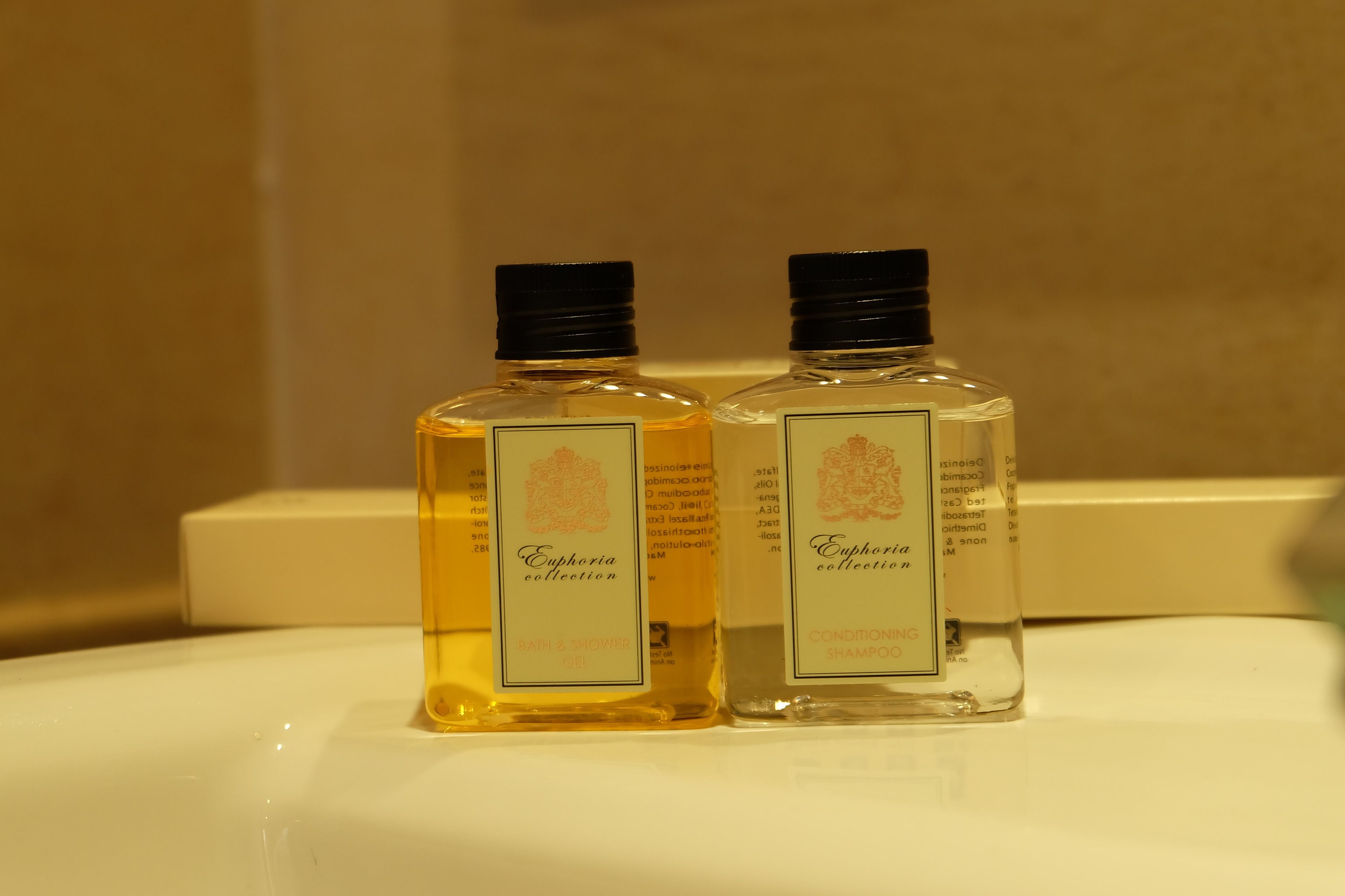 Two bottles of Euphoria Collection Baby & Nourish and Conditioning Shampoo on a white surface.