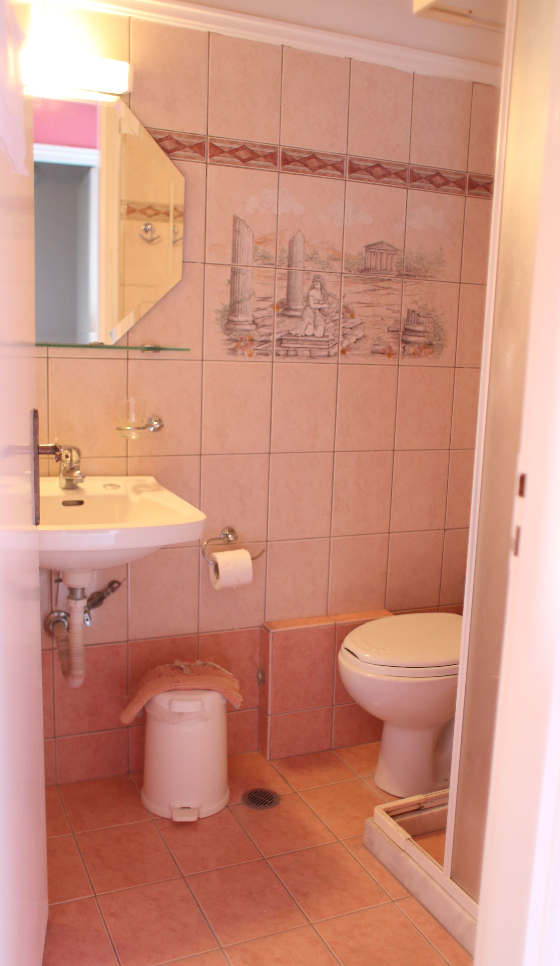 Ein Badezimmer mit Waschbecken, Toilette und Mülleimer.