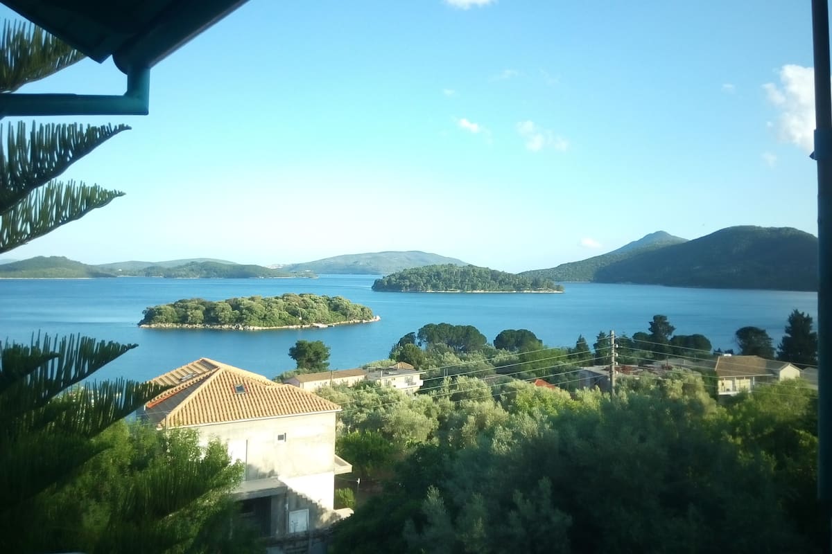 A coastal view with a clear sky, a large body of water, and several islands.