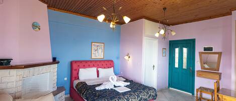 Quarto com cama rosa, lareira de pedra, teto de madeira e porta verde-água.