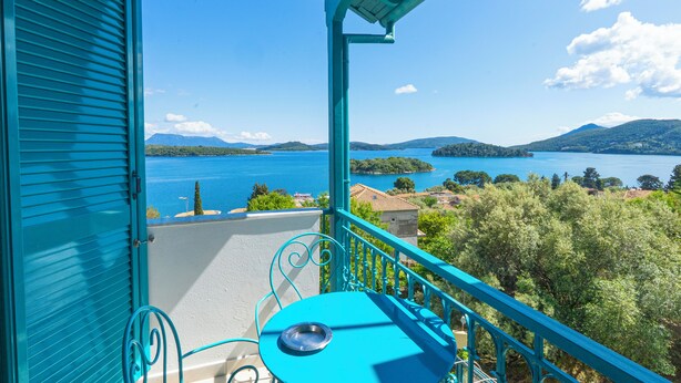 En balkon med udsigt over en sø og bjerge.