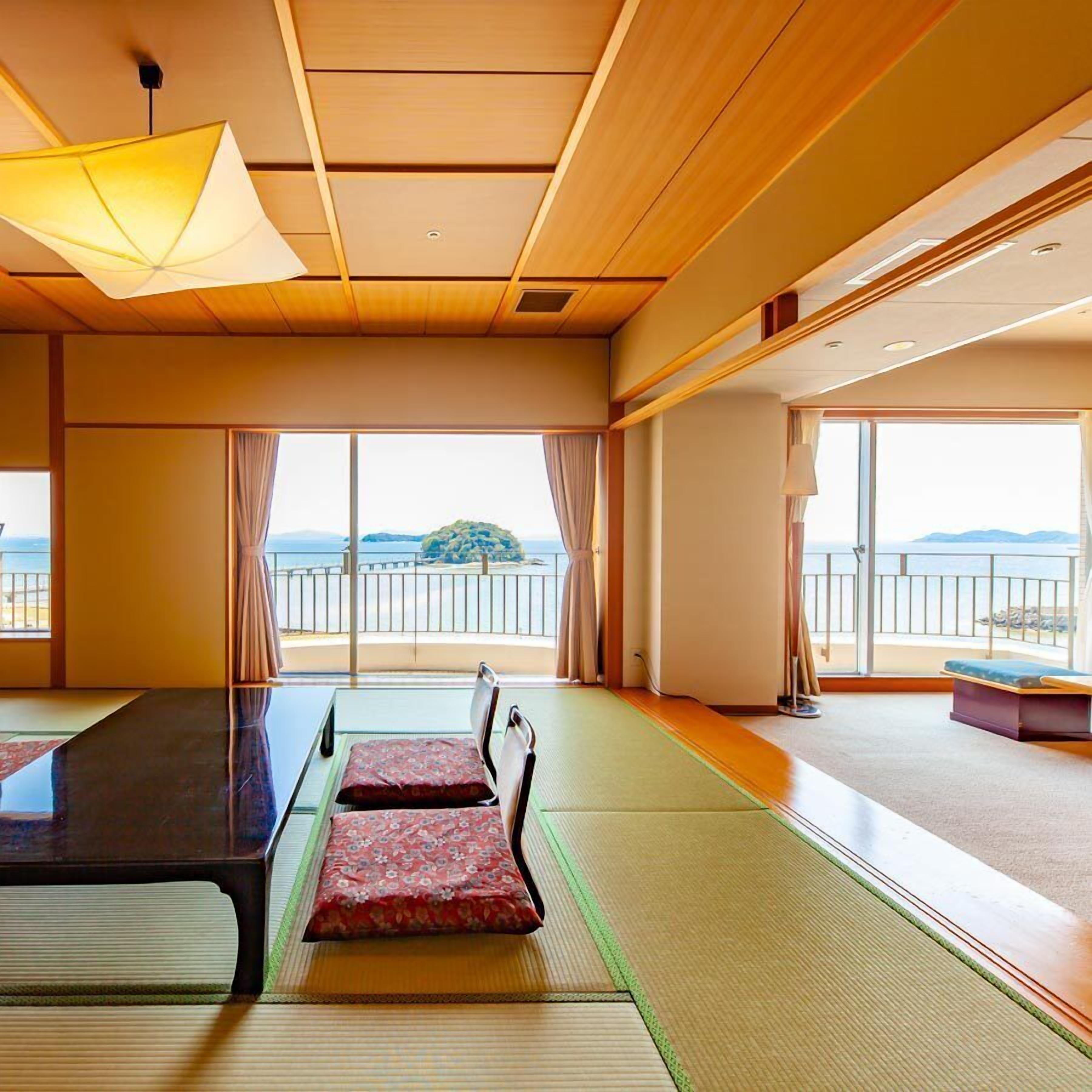 Una habitación con esteras de tatami, una mesa baja y vista al mar.