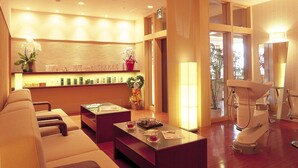 A hotel lobby with a reception desk, seating area, and a massage chair. - Hotel Takeshima (Gamagori)
