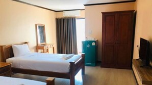 A hotel room with a bed, a desk, a television, and a wardrobe. - B.P Grand Service Apartment (Chiang Mai)