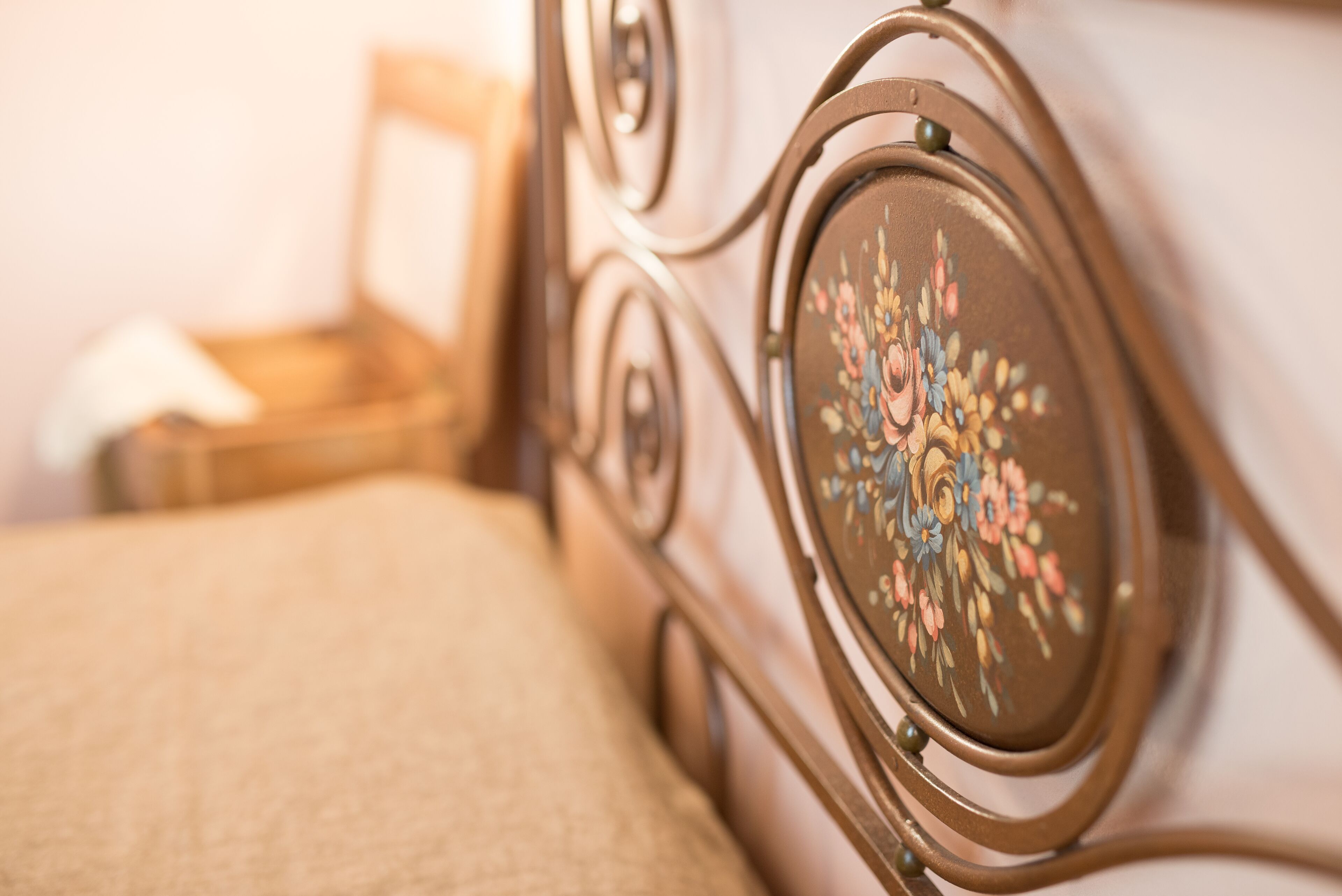 Primer plano de una cama con un cabecero decorado con un diseño floral.